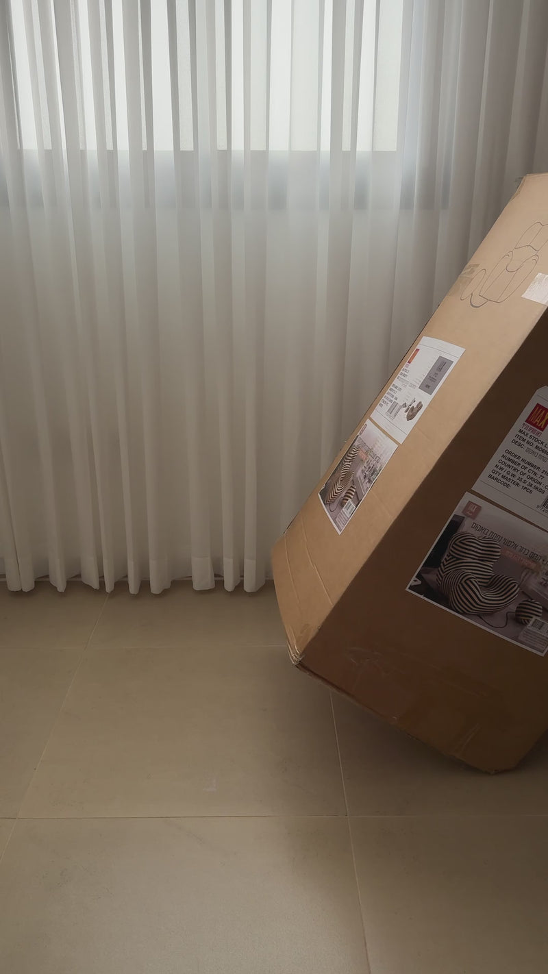 סרטון שממחיש את תהליך הפתיחה וההרכבה של כורסה עם פסים בליווי כדור שמחובר אליה עם חוט מבית מקס סטוק